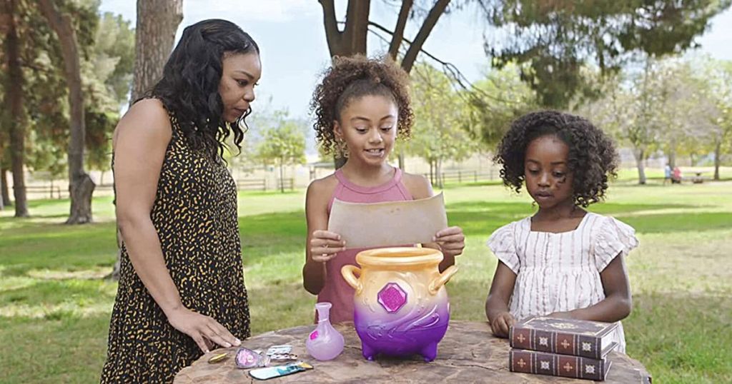 woman and 2 girls playing with Magic Mixes Misting Cauldron in park