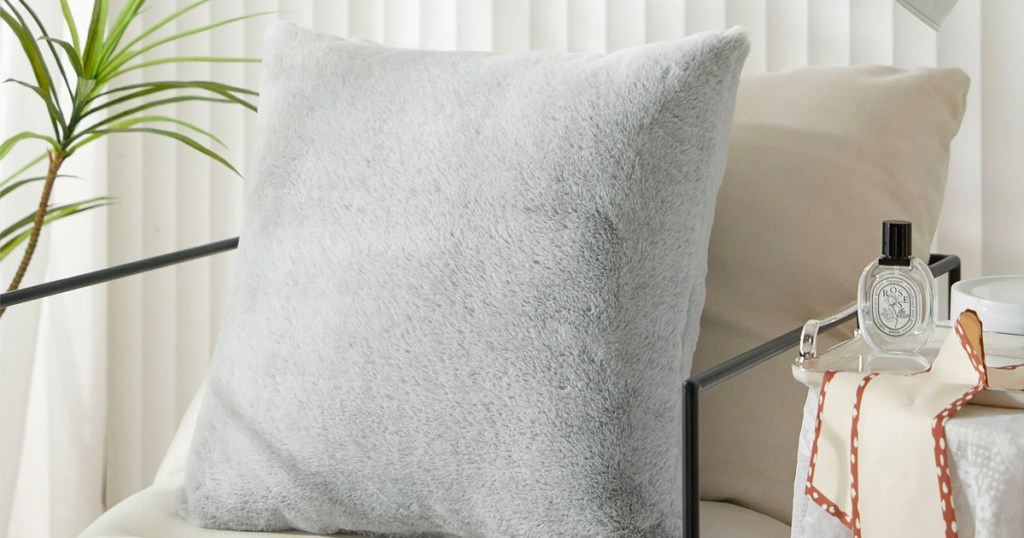 gray faux fur pillow on beige chair