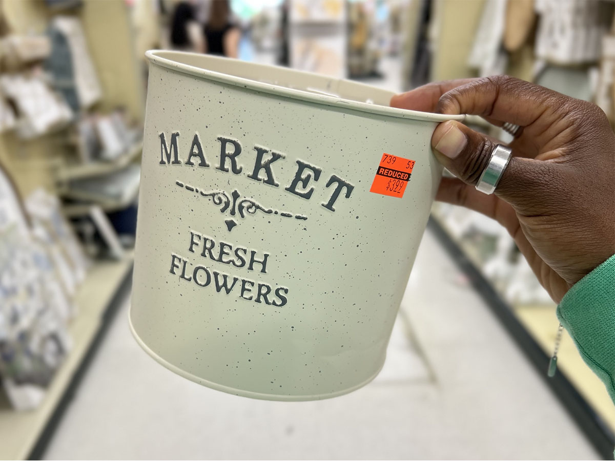 hand holding market fresh flowers white pot