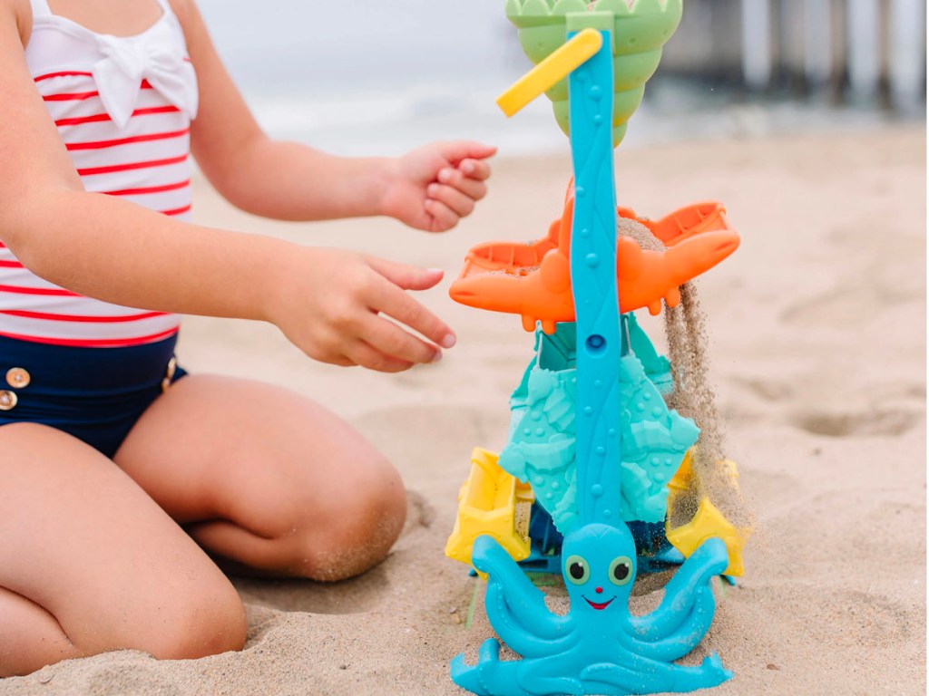 child playing with melissa and doug sand and water sifting funnel 