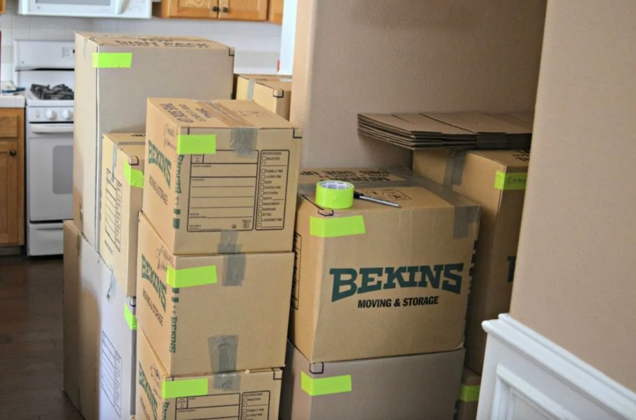moving boxes with bright green yellow color coded duct tape in kitchen