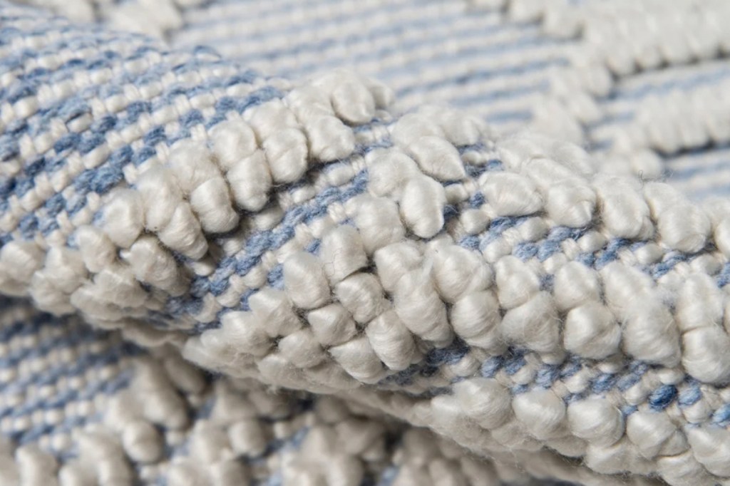 close up of white and blue patterned rug 
