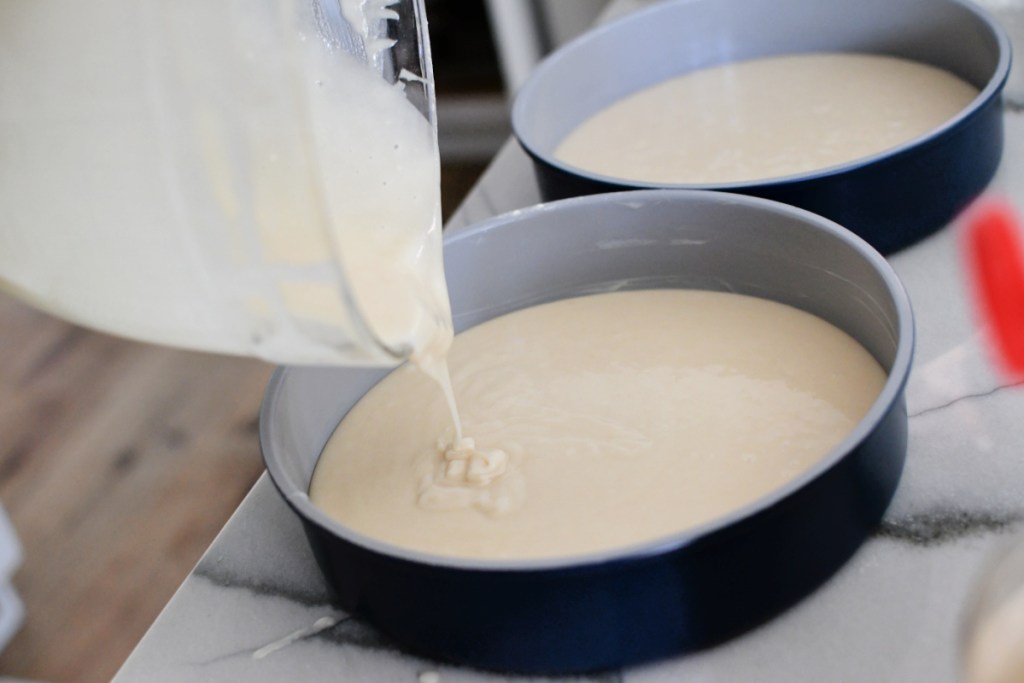 pouring cake batter into caraway cake pans