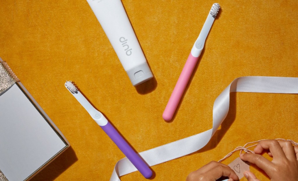 pink and purple smart toothbrushes next to ribbon