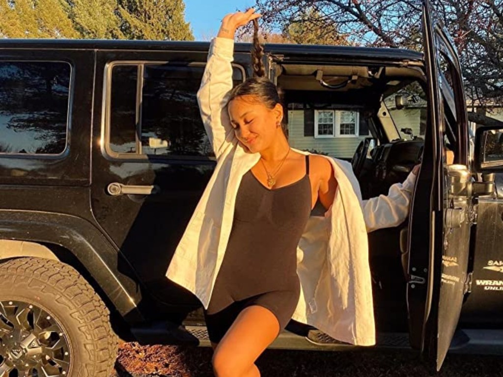 woman wearing black shapewear standing outside black Jeep