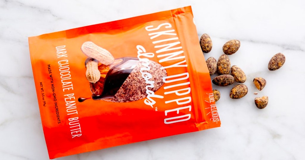 skinny dipped almonds pack open with almonds pouring out on table