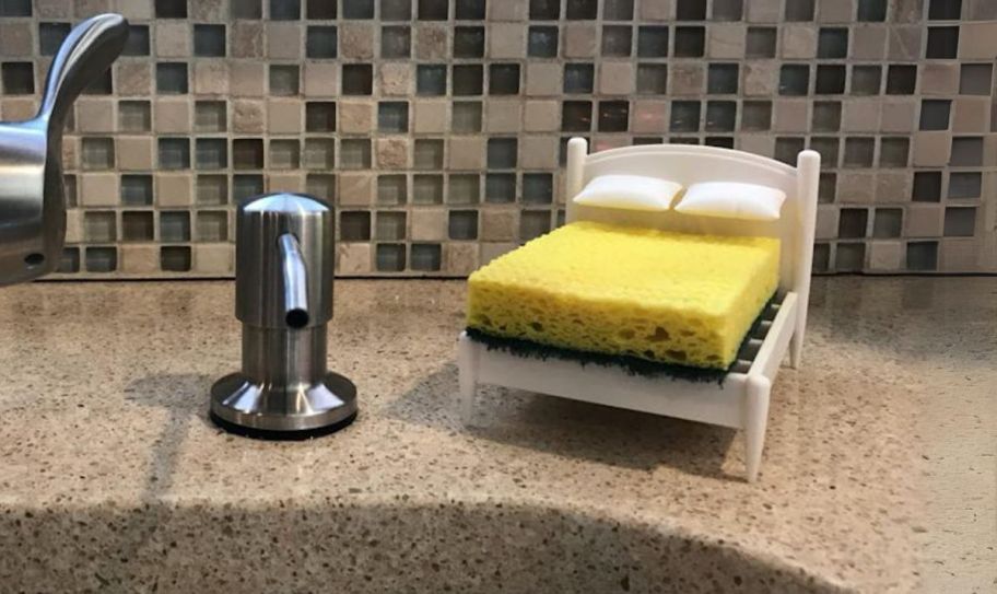 a sponge on a bed-shaped sponge holder with pillows