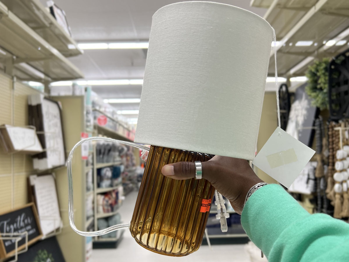 hand holding yellow and white lamp