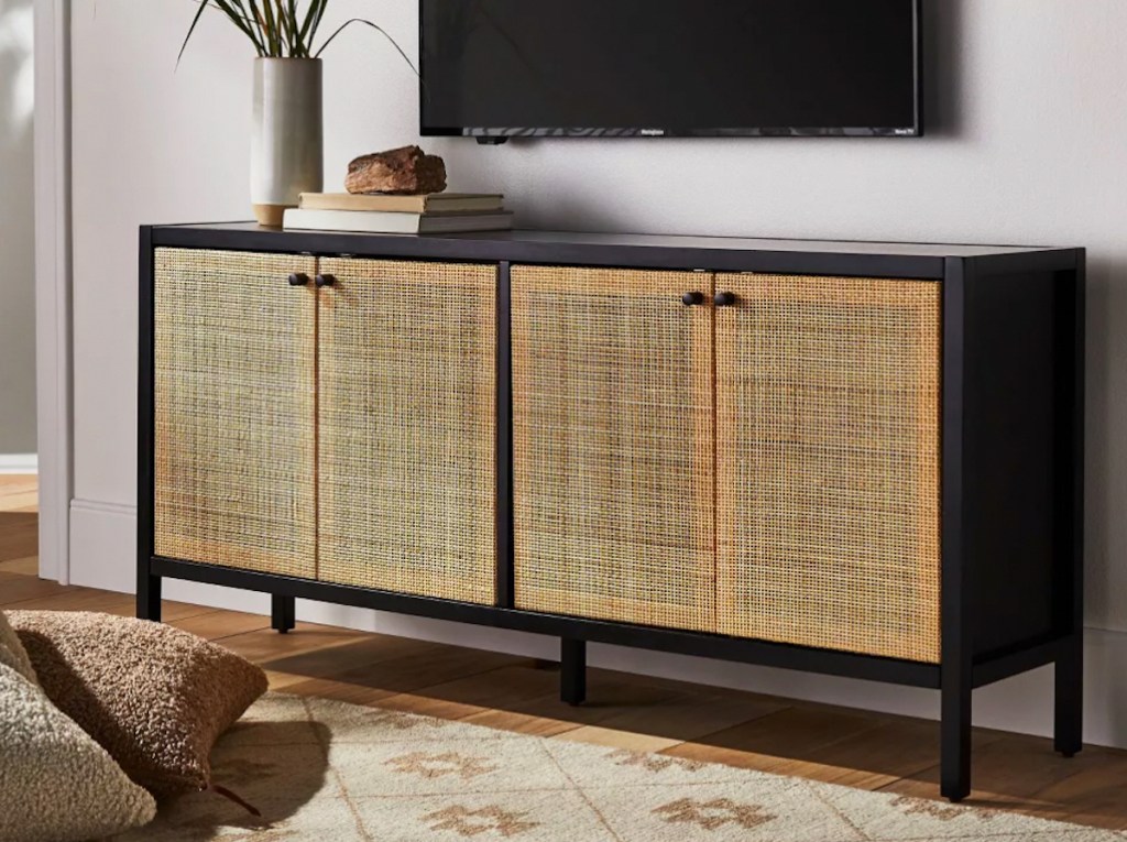natural and black caned console table styled in living room under tv