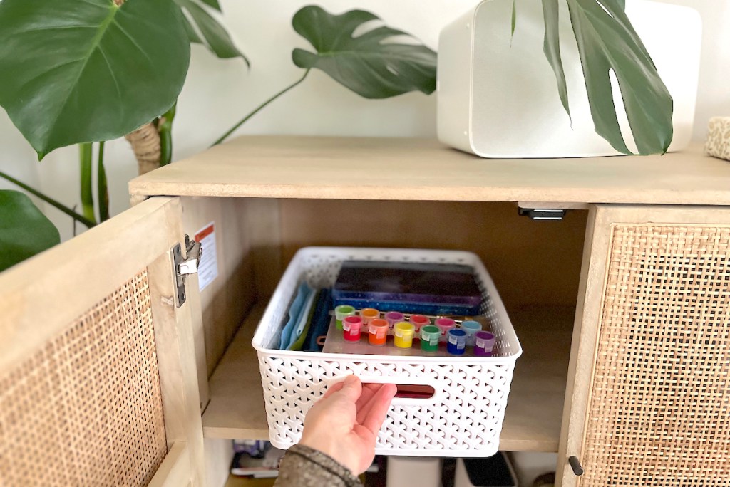 hand pulling white organizer from cabinet