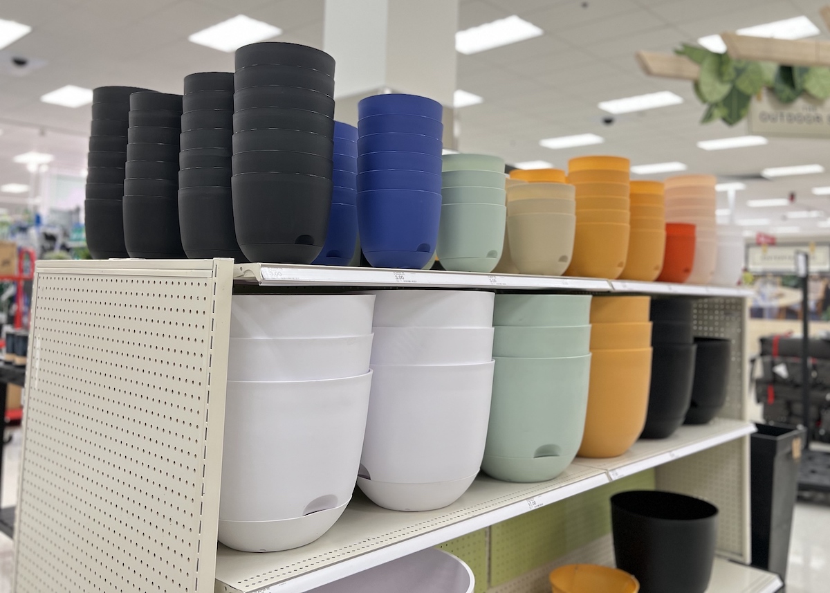 various colors and sizes of self watering planters stacked on store shelves