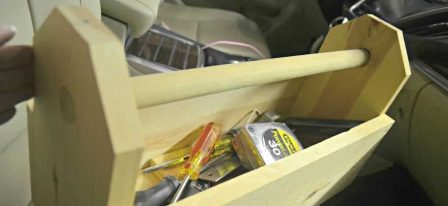 wooden toolbox with measuring tape and tools inside