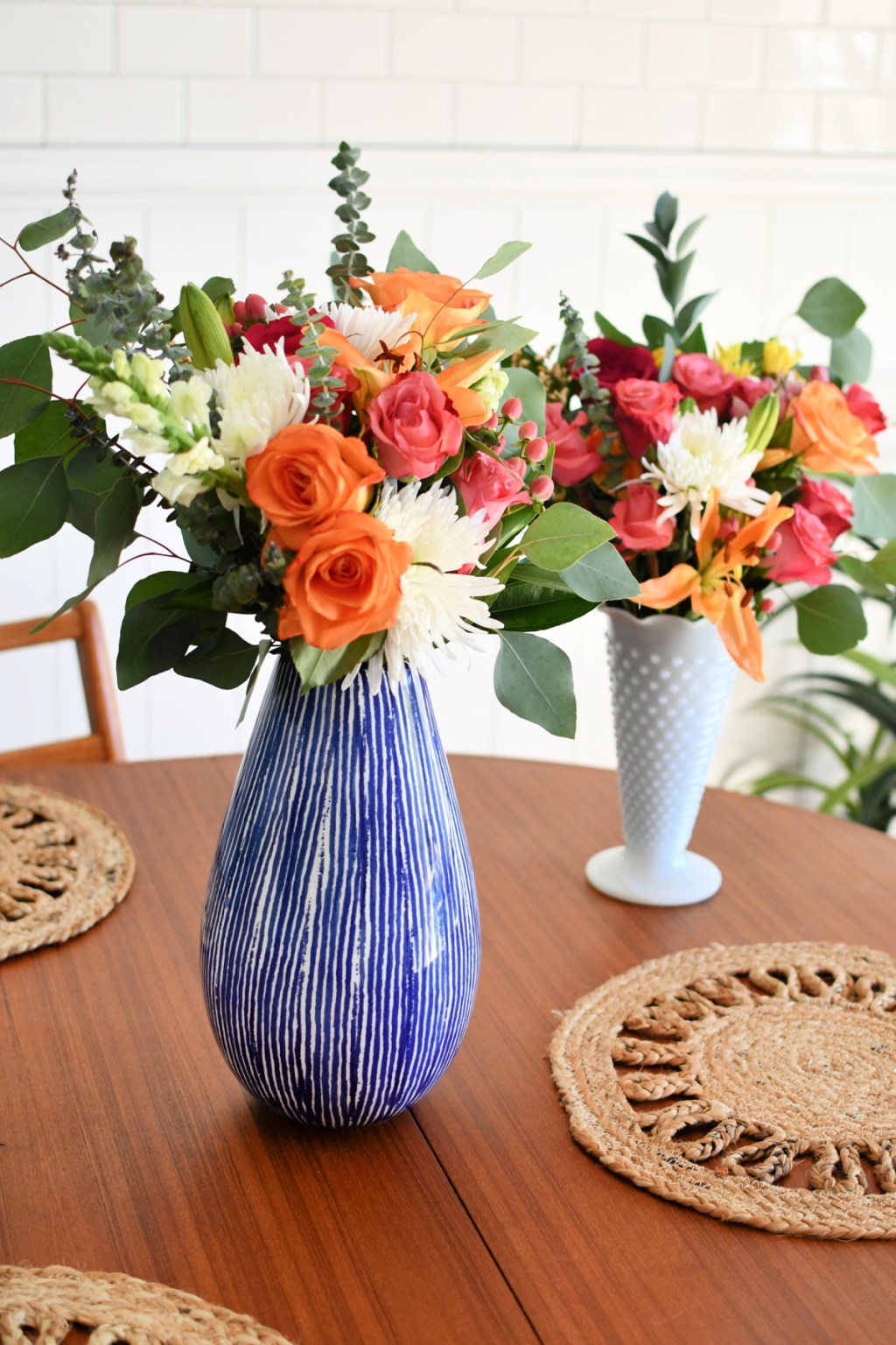 two vases with grocery store flowers inside