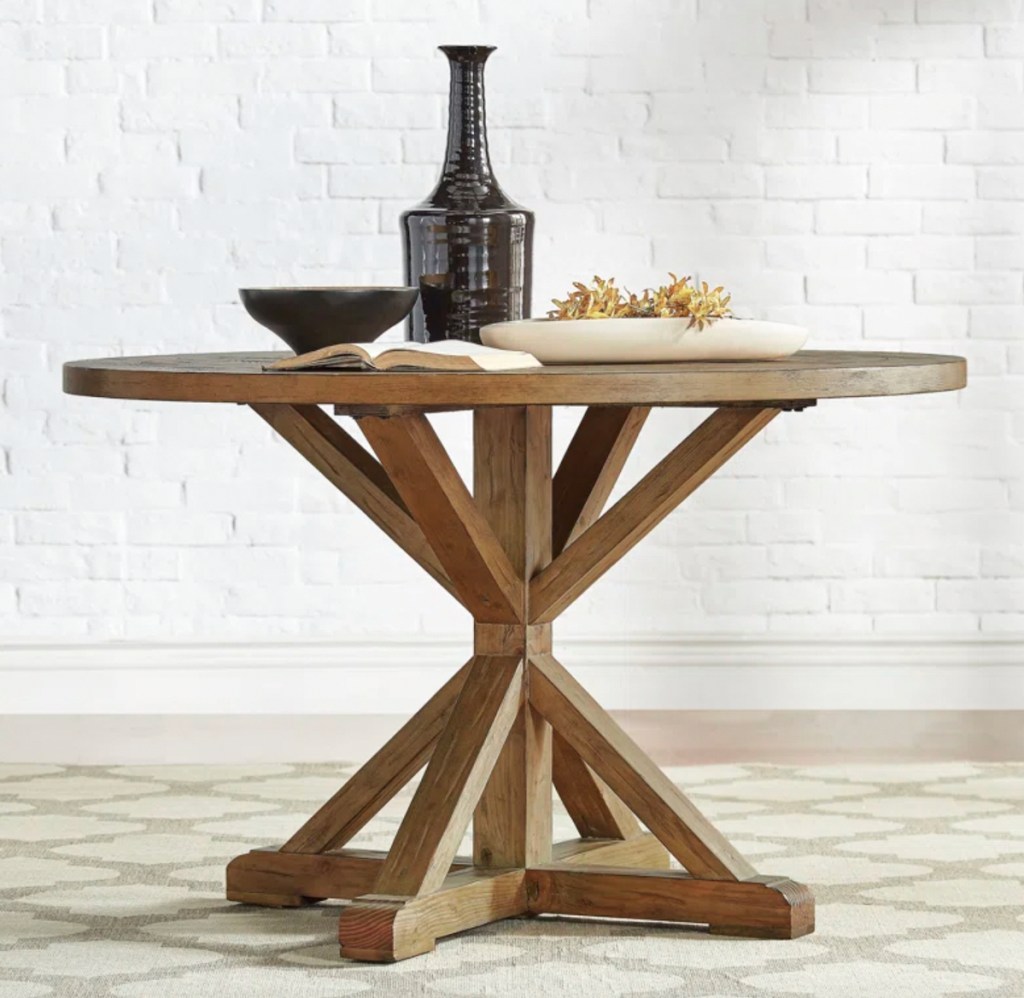 solid wood pedestal dining room table on rug 