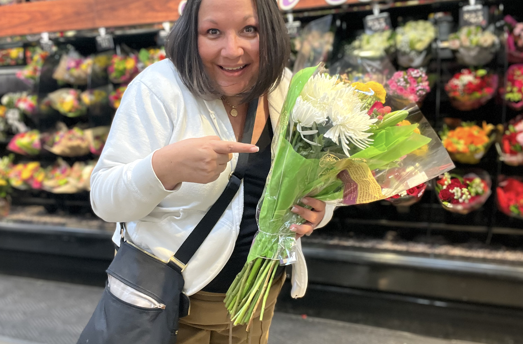 woman holding flowers at grocery store 
