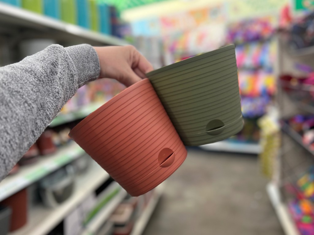 woman holding two Round Plastic Planters with Spouted Saucers at the store
