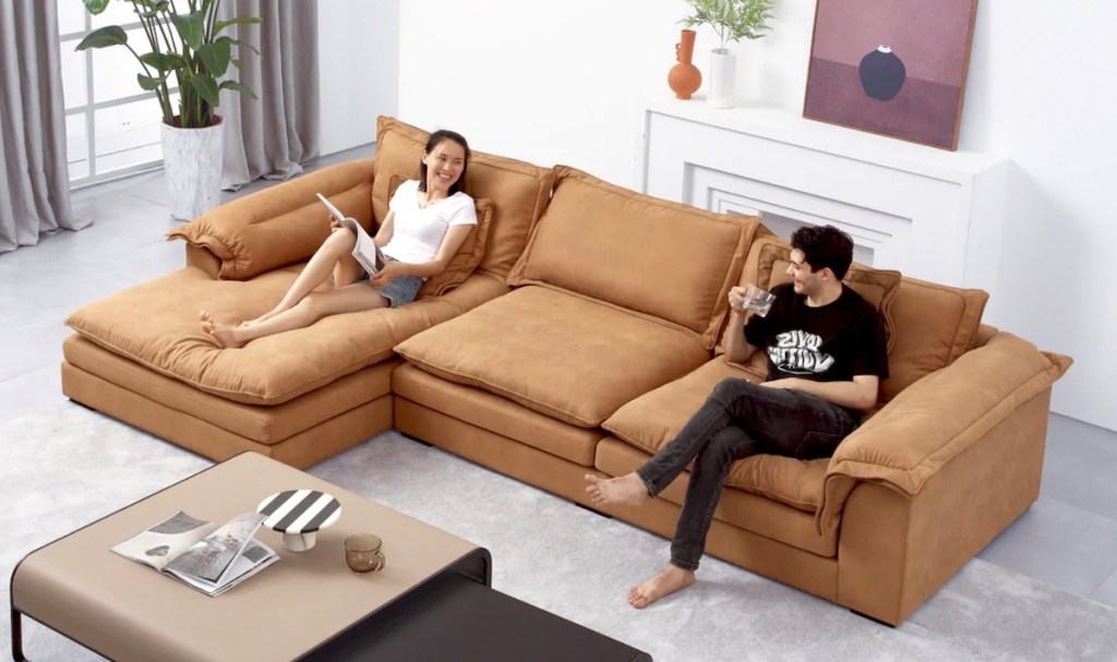 couple sitting on camel colored sectional in living space
