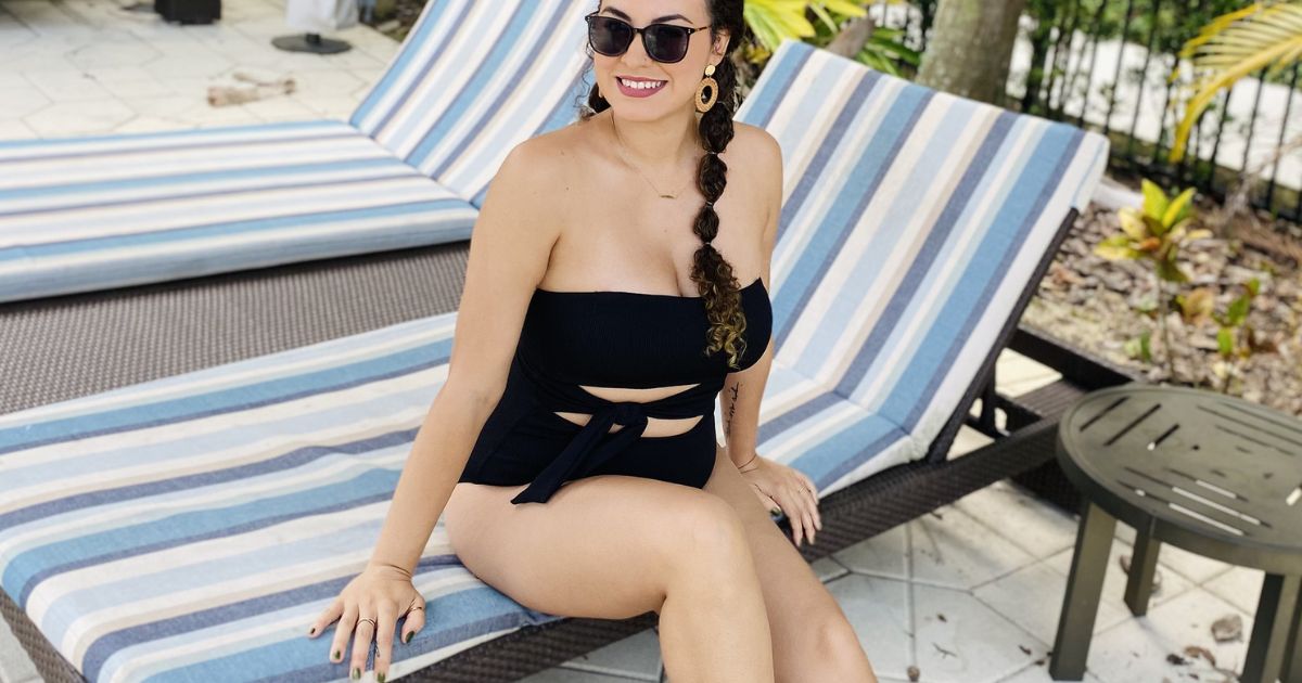 Woman sitting on a lounge chair in an Aerie Swimsuit