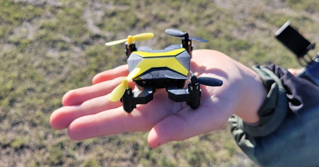 Childs hand open, palm side up with a mini drone in it