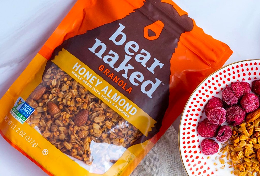 Bear Naked Honey Almond Granola bag shown with bowl of granola and berries