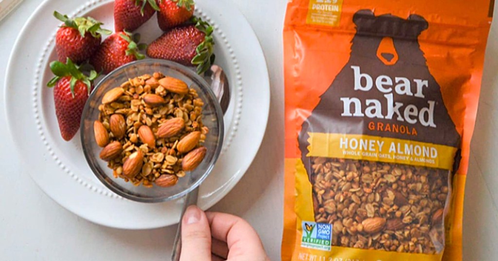 Bear Naked Honey Almond Granola shown in the bag and with a plate of fruit and bowl of granola