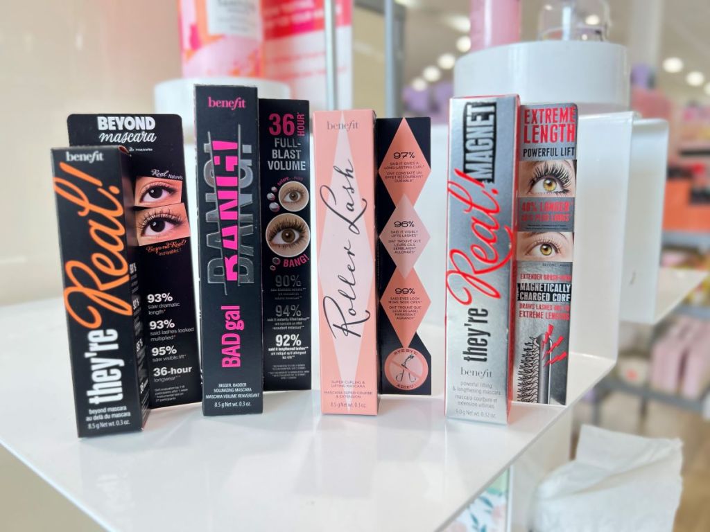 Row of Benefit cosmetics mascaras on a shelf at a store