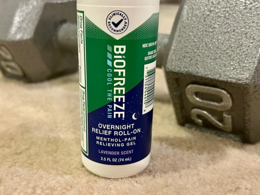 biofreeze overnight relief roll on gel bottle next to dumbbell 