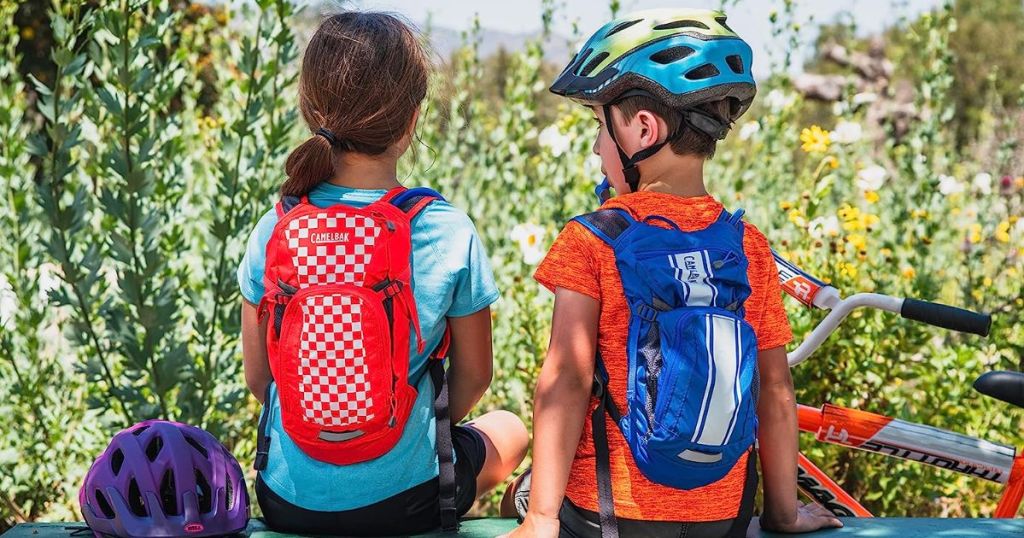 two kids hiking with hydration backpacks