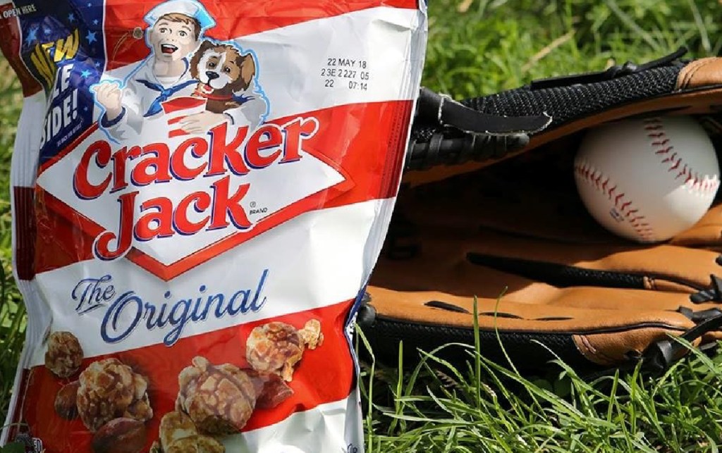 Cracker Jack original treat on the grass next to a baseball pit and ball