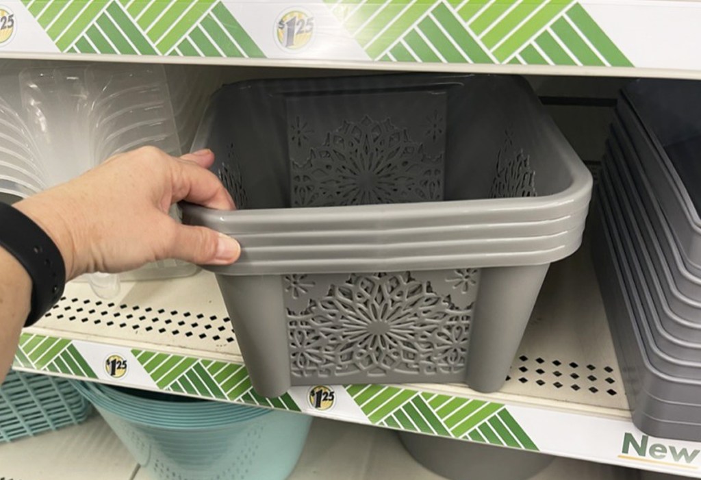 hand grabbing stack of storage baskets from shelf