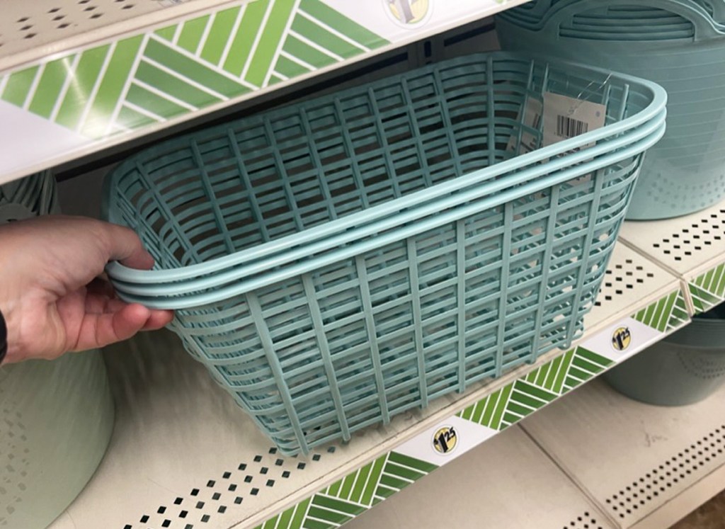 hand grabbing stack of storage baskets from shelf