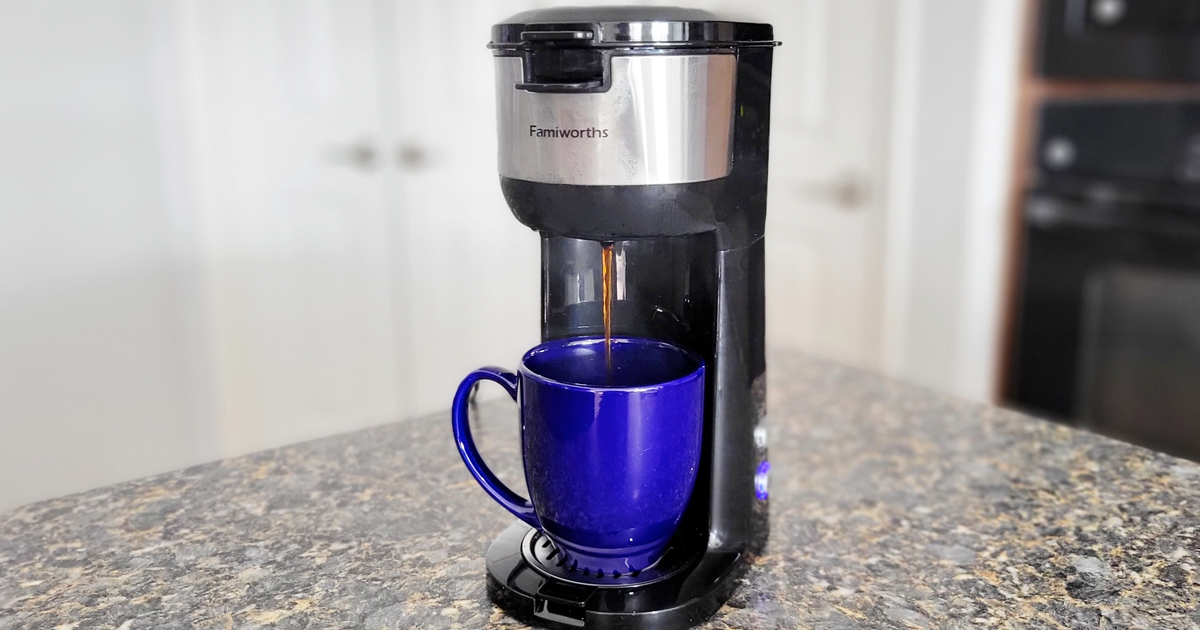 black and silver coffee maker brewing into a blue mug