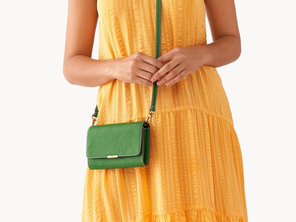 person wearing green Fossil crossbody bag