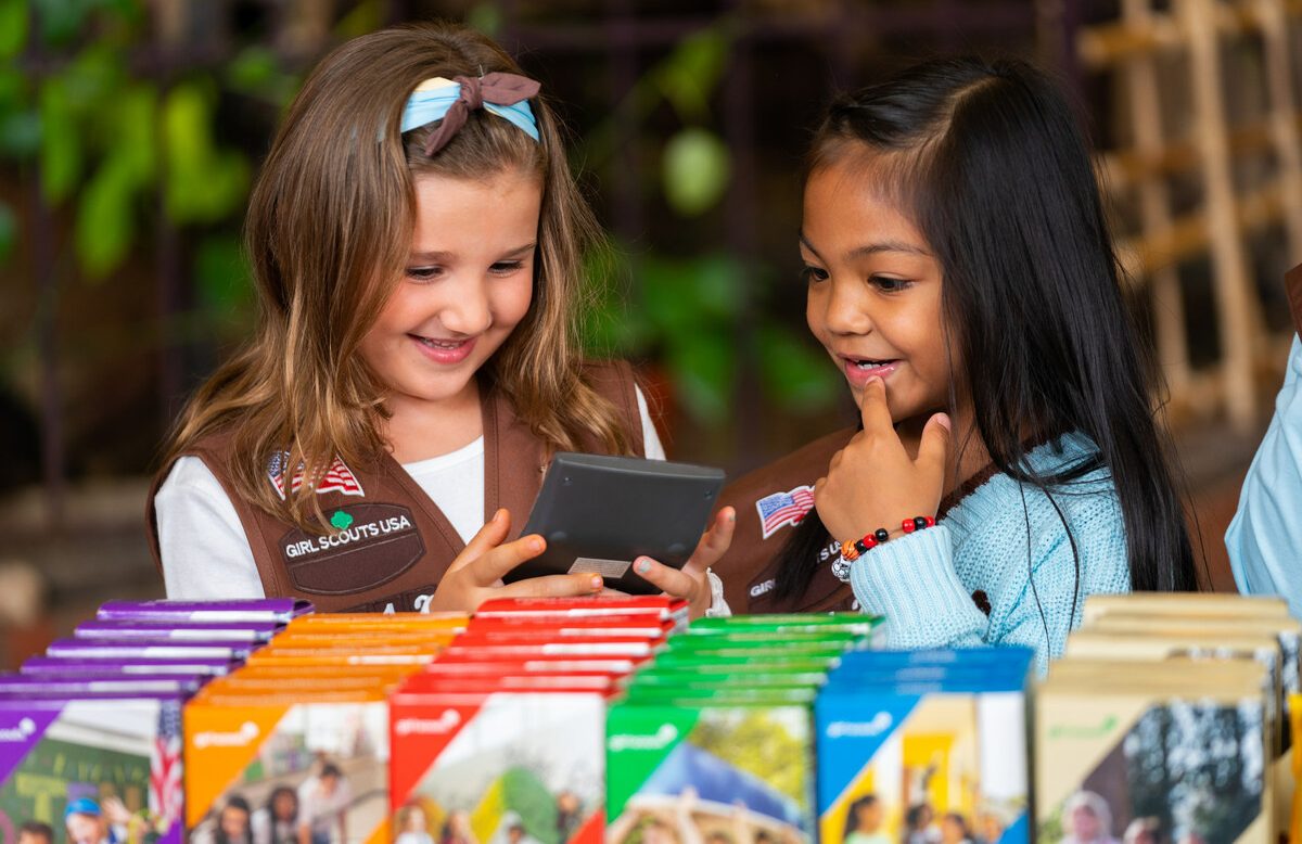 Two girl scouts selling girl scout cookies