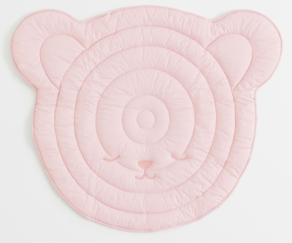 Pink playmat that is shaped like a bears head