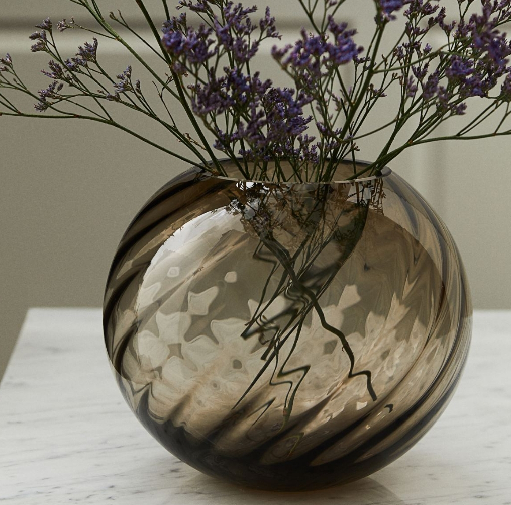 Round glass vase with lavendar in it