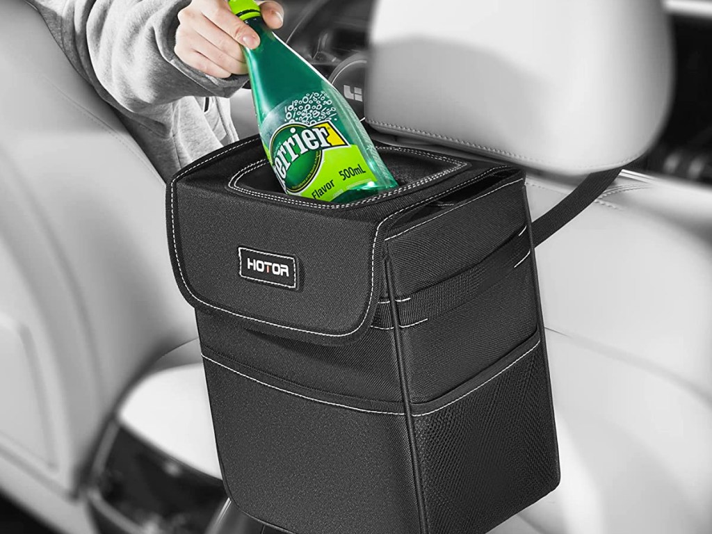 putting perrier bottle into car trash can