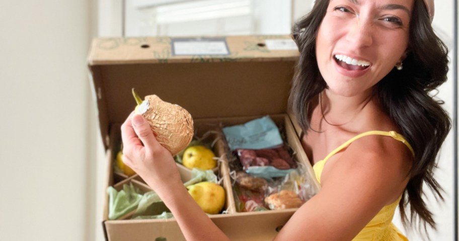woman holding pear from harry and david box