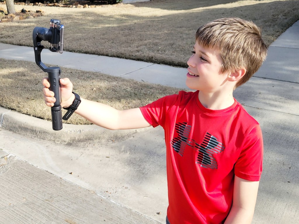 boy holding up a gimbal with smartphone