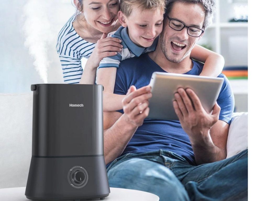 Mother, son and father REALLY enjoying whatever is on the screen of the iPad the father is holding while sitting next to a humidifier