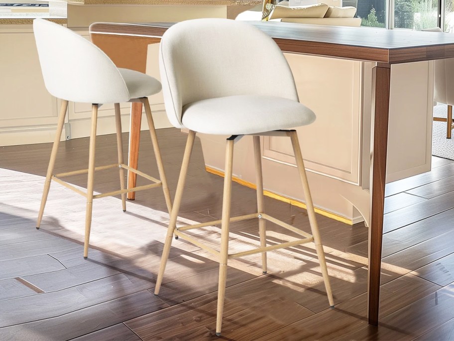 two white and wood barstools at kitchen counter