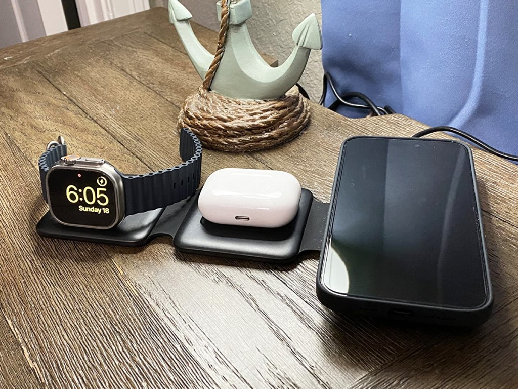 iphone, airpods, and apple watch all placed on a black charging station