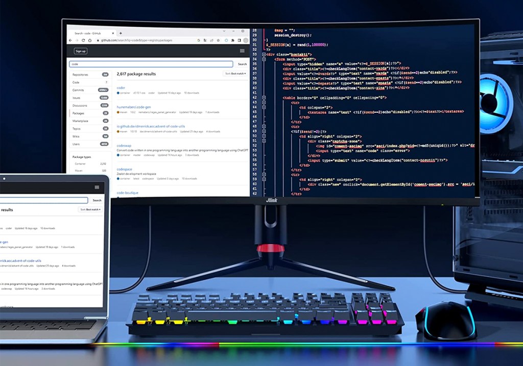 curved computer monitor near laptop and rgb keyboard