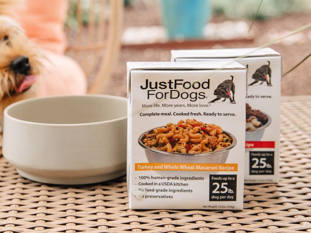 Just Food for Dogs boxes sitting on a table by a dog bowl