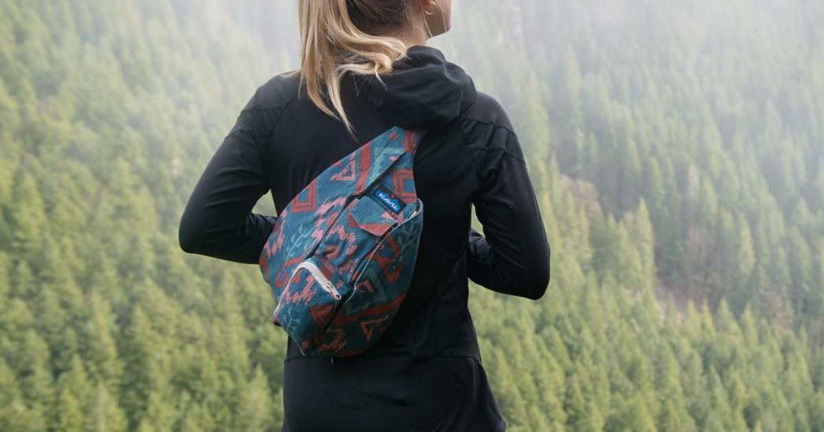 woman wearing kavu bag looking out at trees on mountain