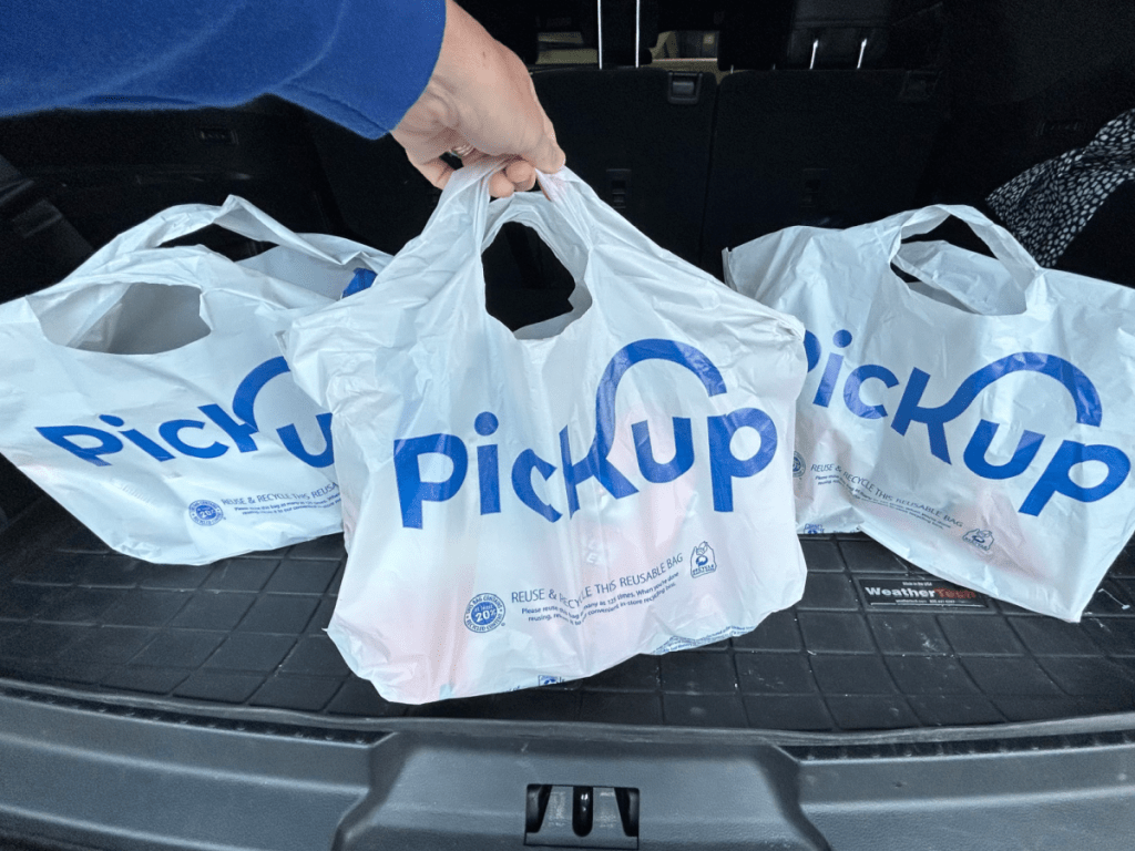 3 white Kroger Pickup bags in the trunk of a gray car