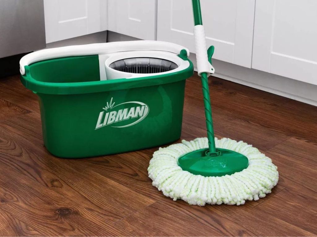 Green and white mop next to a mop bucket
