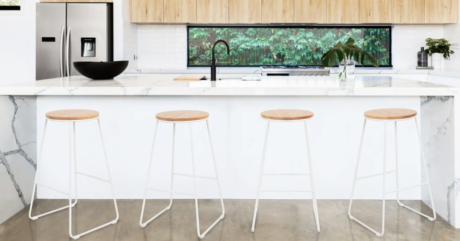 four white metal backless barstools at kitchen counter