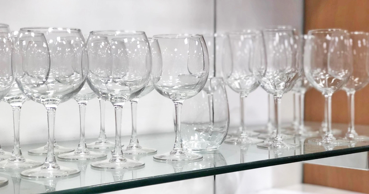 store display of wine glasses on glass shelf