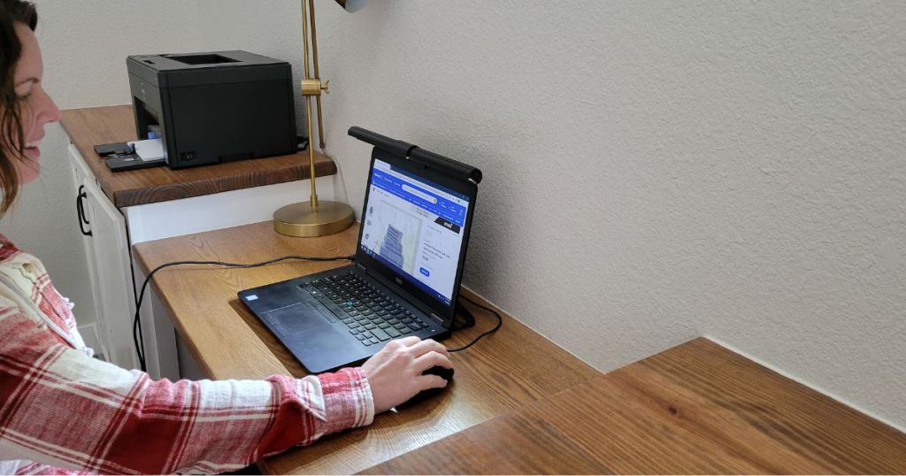 woman using laptop with screenbar monitor light on laptop 